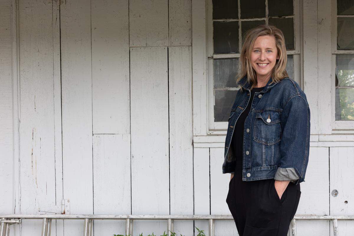 Emily Smith, executive director of Karla Smith Behavioral Health, stands in front of an outbuilding that will be used as an “art barn” at the organization’s new location on a former farm near Belleville West High School.